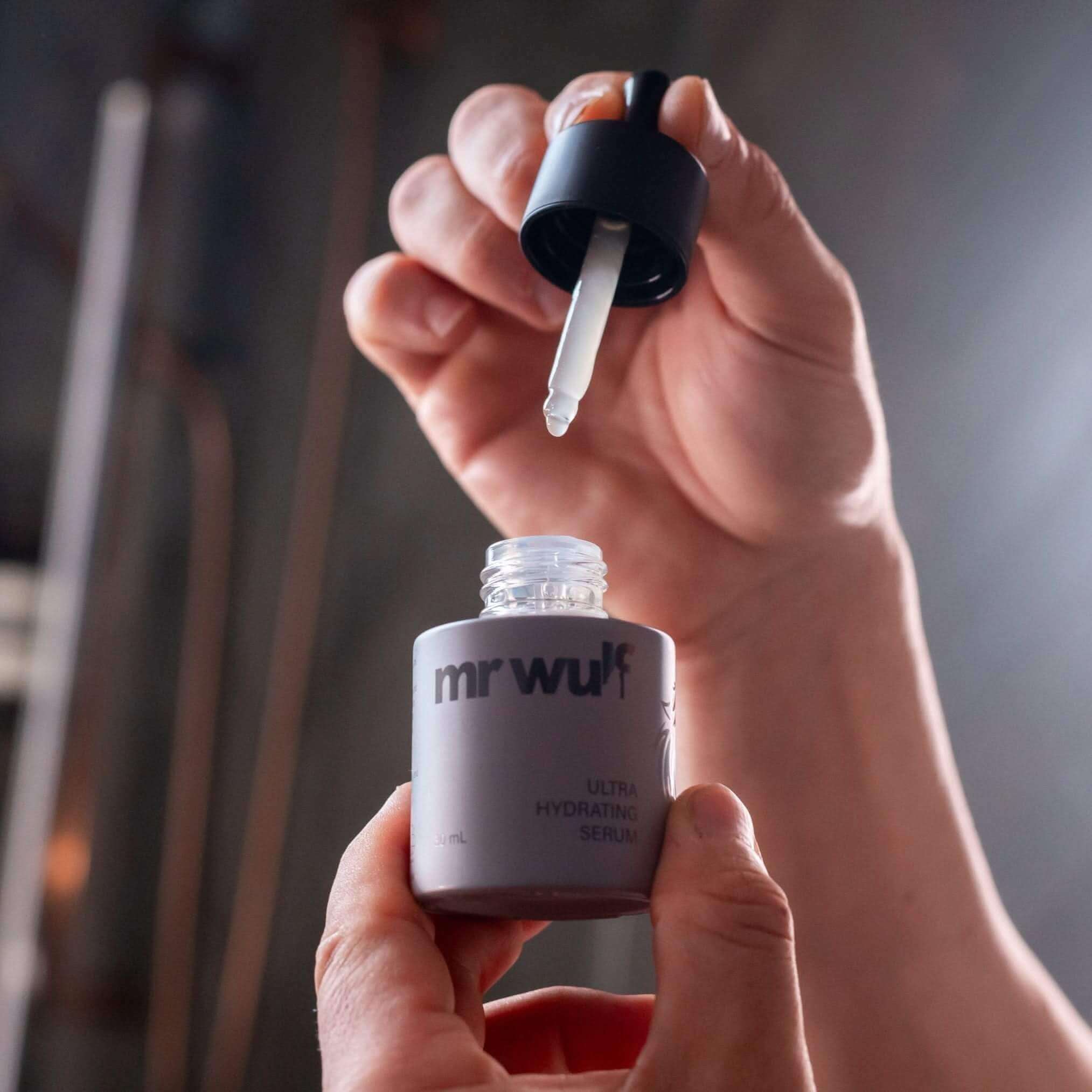 Man applying serum from Power Pair skincare set
