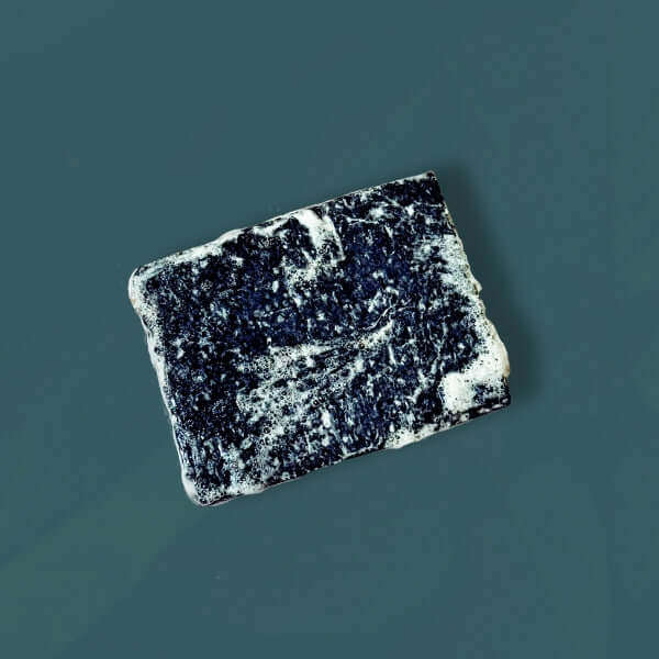 Charcoal Soap lathered up on dark grey background