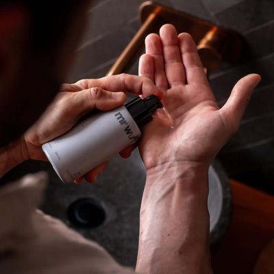 Person dispensing product from the Essential Mens Skincare Kit – Wulf Starter Pack for hydration.