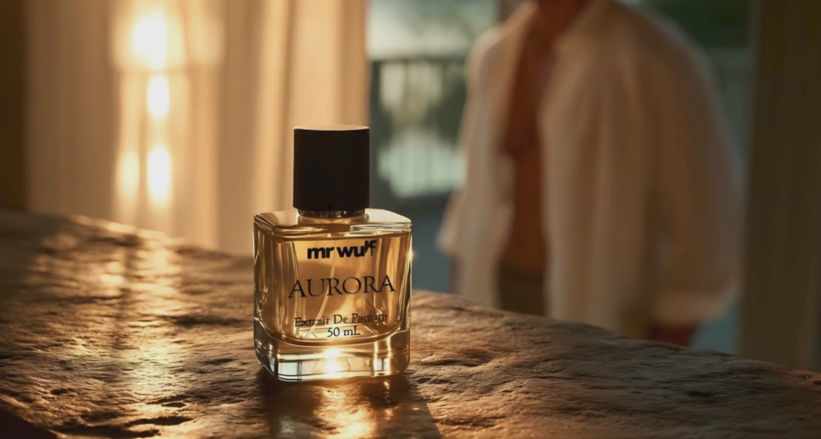 Load video: man standing in a room at sunset, the curtains gently flutter and he moves towards the bottle of Mr Wulf Aurora Cologne